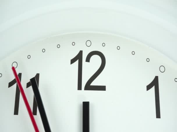 Zbliżenie biały zegar ścienny twarz początku czasu 12,56 am lub PM, zegar minut chodzić powoli, koncepcja czasu. - Materiał filmowy, wideo