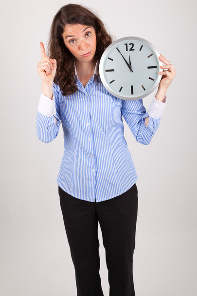 The young business woman is holding a big watch in her hands - Foto, immagini