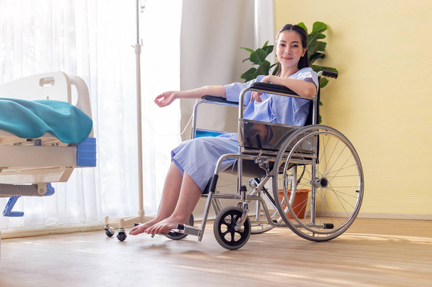 Donna disabile seduta in sedia a rotelle nella stanza del paziente
. - Foto, immagini