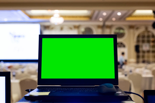 Laptop üres zöld képernyővel a szemináriumi teremben. - Fotó, kép