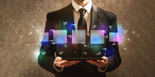 Cajas cuadradas digitales con hombre de negocios sosteniendo una tableta
 - Foto, Imagen