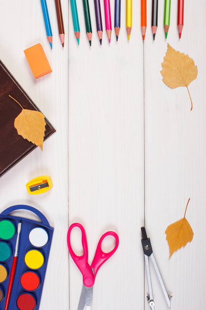 Frame of school accessories, book and autumnal leaves on boards. Back to school concept - Valokuva, kuva