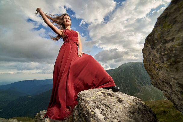 Kaunis nainen muoti malli punainen mekko vuori kiviä
 - Valokuva, kuva