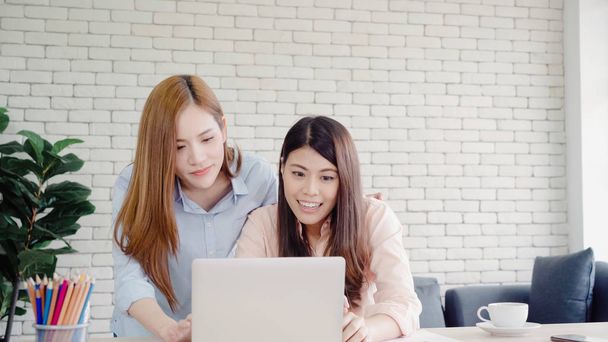 Atrakcyjna inteligentna creative azjatycki biznes kobiety w smart na co dzień noszą pracy na laptopie siedząc na biurko w biurko. Styl życia kobiety pracują w biurze concept. - Zdjęcie, obraz