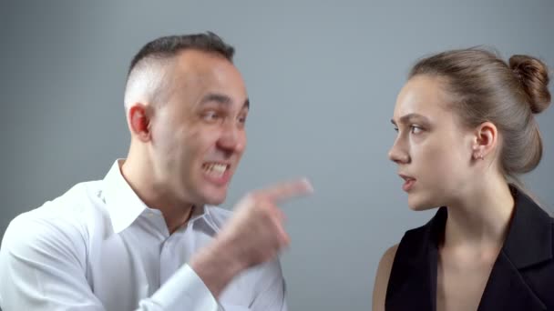 Video von schreiendem Mann auf Mädchen auf grauem Hintergrund - Filmmaterial, Video