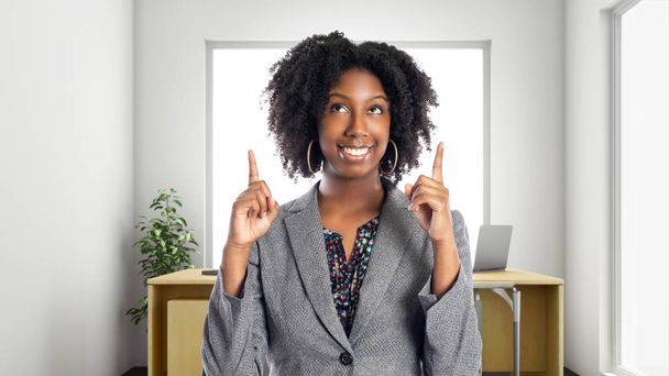 Black African American businesswoman in an office advertising or presenting something.  She is an owner or an executive of the workplace.  Depicts careers and startup business.  - Photo, Image