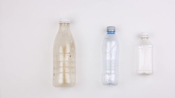 different used dirty plastic disposable tableware and garbage moves on white background, bottles cups bags containers, stopmotion animation, big ecological pollution problem - Footage, Video