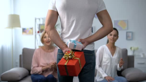 Esposa curiosa e sogra olhando para o homem segurando caixas de presente nas costas
 - Filmagem, Vídeo