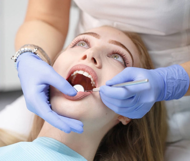 female dentist checking patient girl teeth in a clinic - Фото, зображення