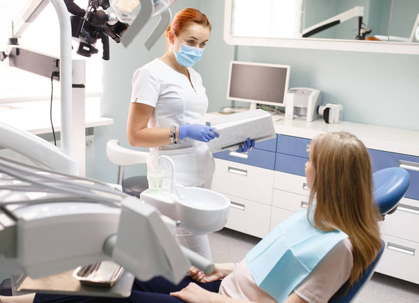 female dentist with patient girl talking at dental clinic office - Foto, Bild