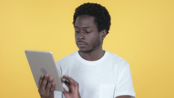 Young African Man Excited for Success while Using Tablet Isolated on Yellow Background - Video