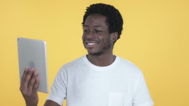 Video Chat by Young African Man via Tablet Isolated on Yellow Background - Video