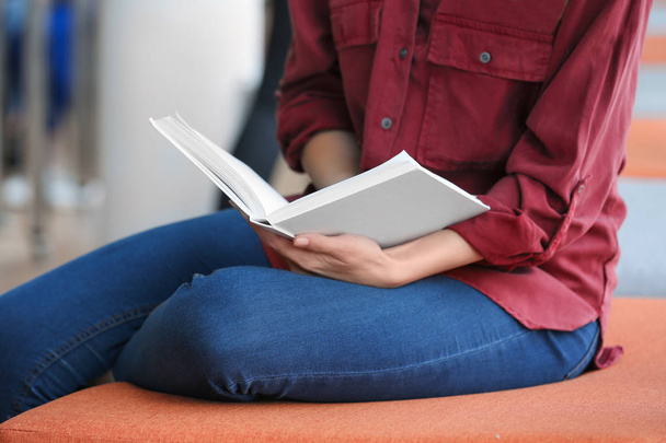 Young woman reading book in library, closeup - Photo, Image