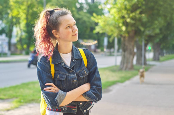 Serious teen schoolgirl with backpack, hands crossed - 写真・画像