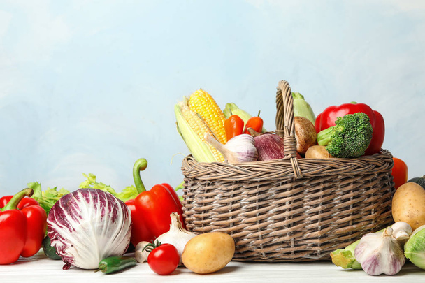 Fresh vegetables and wicker basket on white wooden table - Photo, Image