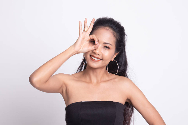 Beautiful young Asian woman show OK sign over her eye. - Valokuva, kuva