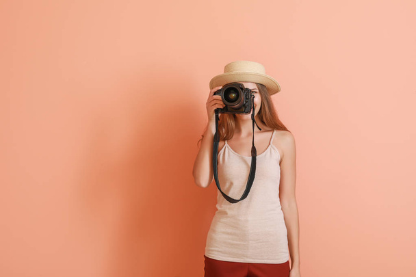 Young female photographer on color background - Valokuva, kuva