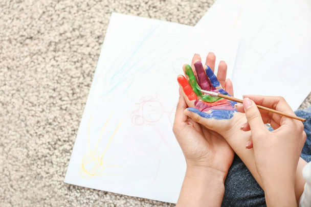 Η μητέρα ζωγραφίζει τα χέρια του μικρού γιου της στο σπίτι - Φωτογραφία, εικόνα