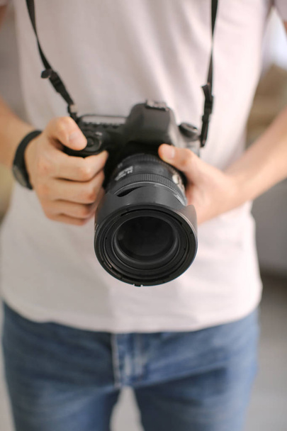 Tiener jongen met fotocamera thuis, close-up - Foto, afbeelding