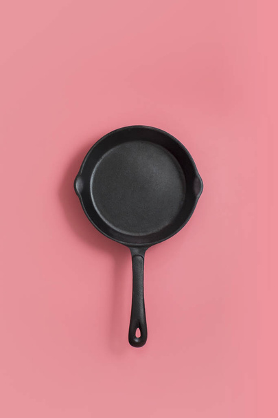 Iron frying pan on pink background. - Photo, Image