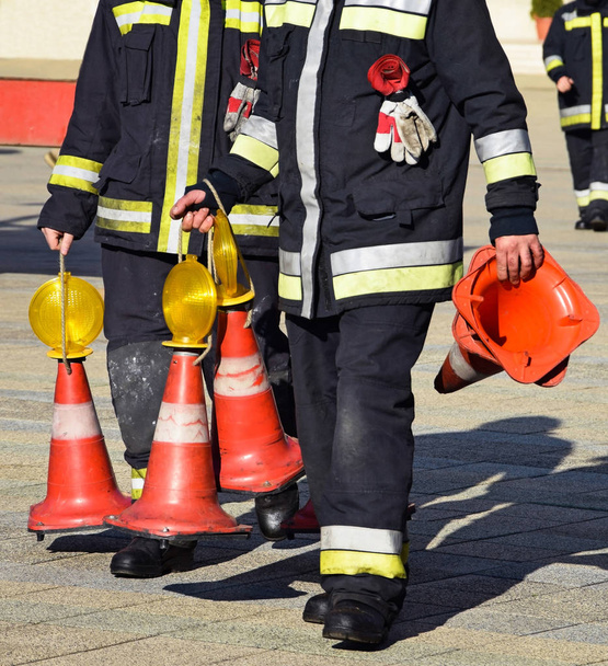 Пожарные с дорожными конусами за работой
 - Фото, изображение