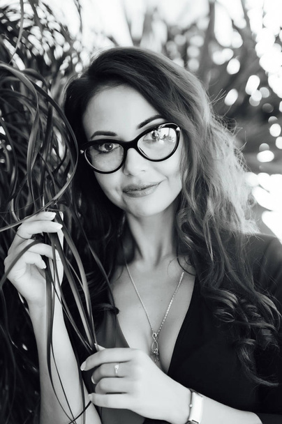 incredibly beautiful girl with glasses in the garden with plants - 写真・画像