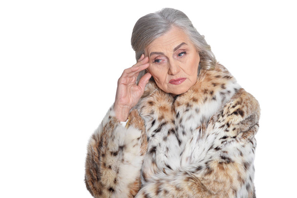 portrait of  beautiful senior woman in fur coat with headache  - Фото, зображення
