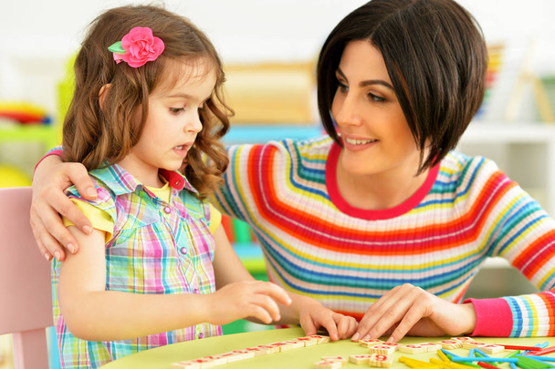 Cute little girl with her mother studying  - Foto, Bild