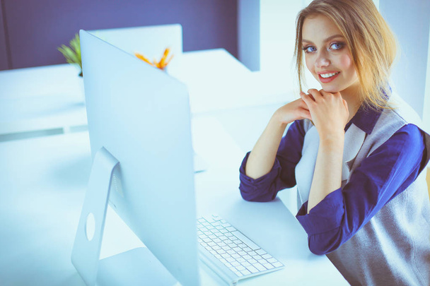 Jonge zelfverzekerde zakenvrouw die op kantoor werkt en typt met een laptop - Foto, afbeelding
