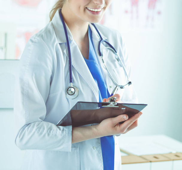 Smiling female doctor with a folder in uniform standing - Foto, Imagen