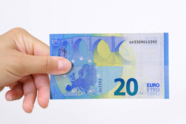 Mão segurando uma nota bancária do euro isolada sem fundo
 - Foto, Imagem