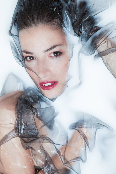 sensual woman portrait with black tulle in milk bath - Photo, Image