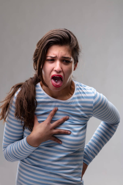 Молодая женщина выражает отвращение или боль
 - Фото, изображение
