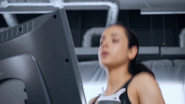 baixo ângulo de visão da bela jovem esportista correndo na esteira no ginásio
 - Filmagem, Vídeo