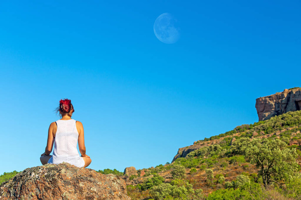 Kobieta na skale Joga Zen postawy medytacja pod sylwetką księżyca na błękitne niebo i słońce - Zdjęcie, obraz