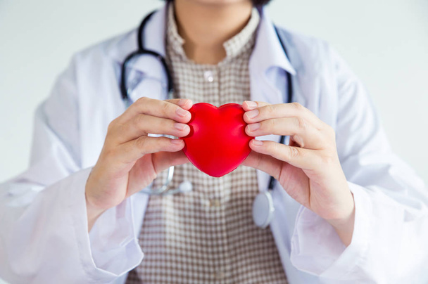 Női orvos kezében egy piros szív labdát. Az egészségügyi ellátás fogalma - Fotó, kép