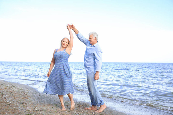 Happy mature couple dancing at sea resort - Photo, Image