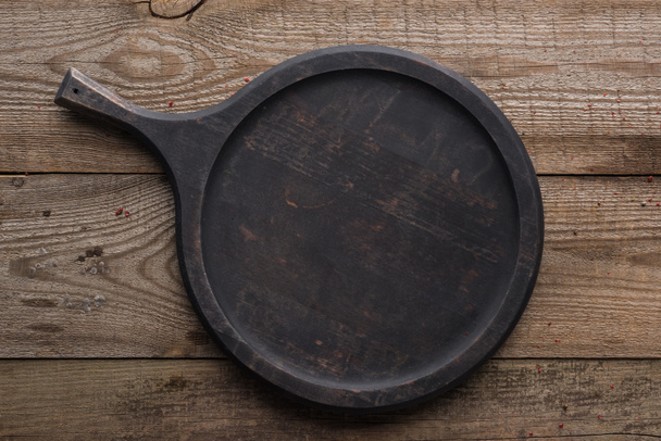 bovenaanzicht van de lege Woode pizza pan op een gestructureerde tafel - Foto, afbeelding
