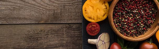 plano panorámico de bandeja negra con pimienta y sal en cuencos, chile, tomates en rodajas y ajo sobre mesa de madera
  - Foto, imagen