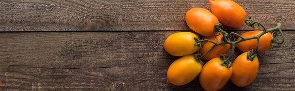 panoramic shot of yellow tomatoes on wooden table  - Photo, image