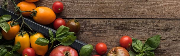 panoramic shot of tomatoes and spinach in box on wooden table  - Foto, afbeelding
