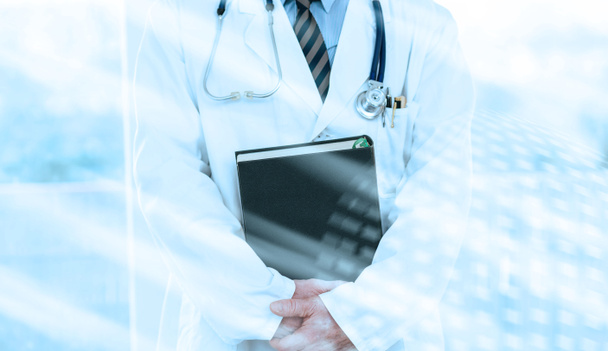 Doctor sosteniendo un libro de texto médico; efecto de luz
 - Foto, Imagen