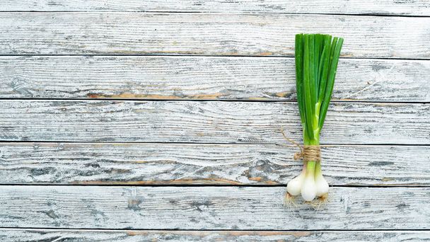 Green onion on a white wooden background. Top view. Free space for text. - Fotoğraf, Görsel