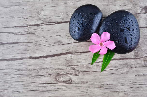 Blume mit Zen-Stein auf Holz-Hintergrund - Foto, Bild