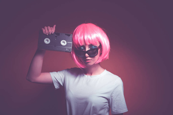 junges Mädchen 90er Jahre und vhs-Kassette auf rosa - Foto, Bild