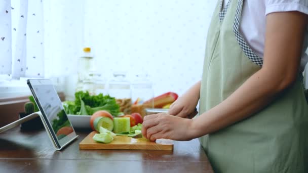 4K. female hand slicing fresh lettuce, prepare ingredients for cooking follow cooking online video clip on website via tablet. cooking content on internet technology for modern lifestyle concept - Footage, Video