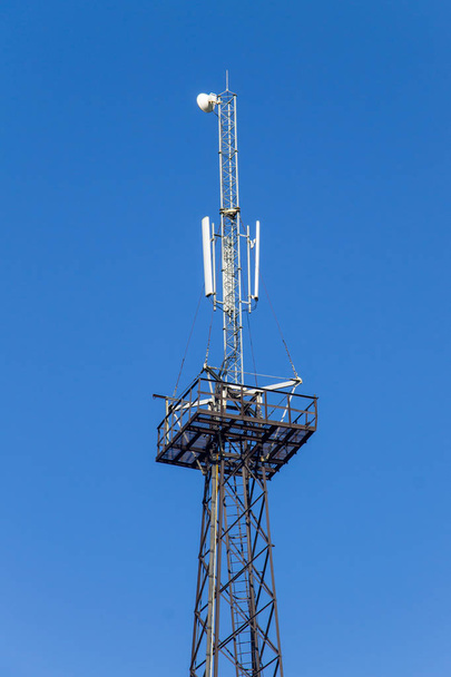 Torre de metal con antenas para comunicaciones de teléfonos móviles contra el cielo azul
 - Foto, imagen