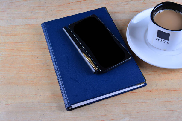 Üres jegyzetfüzet, töltőtoll, smartphone és csésze kávé íróasztal - Fotó, kép