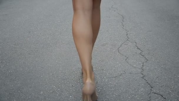 Womans legs in high heel shoes walking on road slow motion. - Filmagem, Vídeo