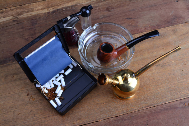 Кальян медный фильтр для курения с табачной трубой на деревянных столах
 - Фото, изображение